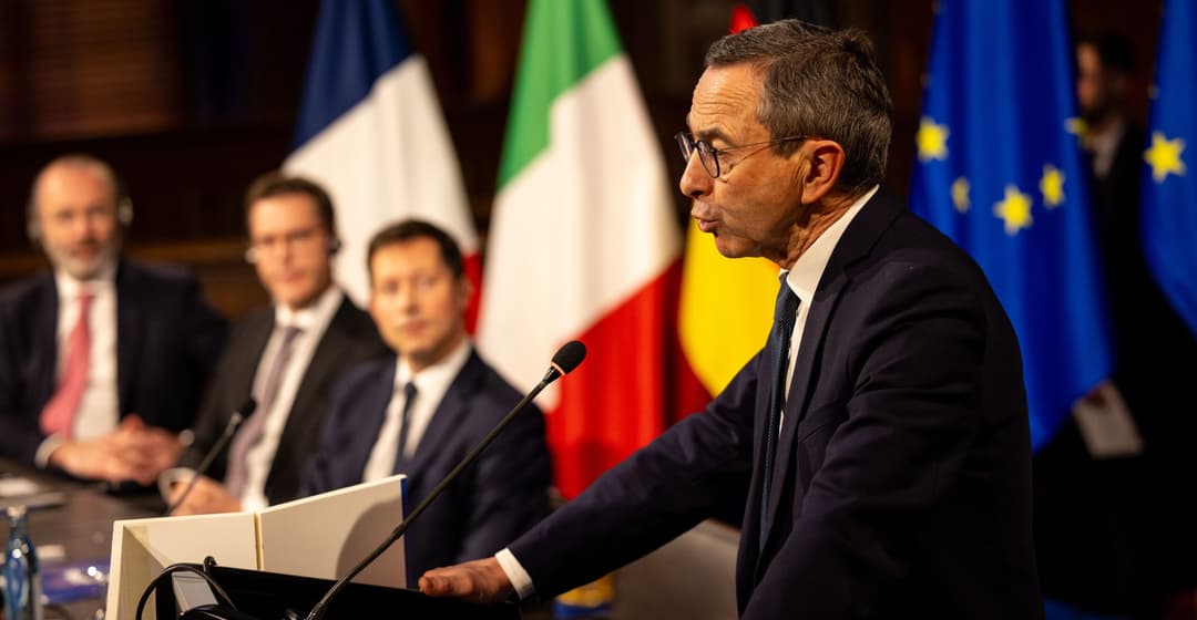 Bruno Retailleau s'exprime à un pupitre, devant des drapeaux français, italien et européens